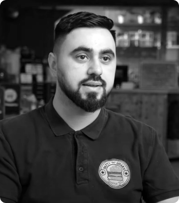 A happy local hero saving with lack of high commission on orders in their restaurant and takeout feeling supported by his Foodhub area manager.